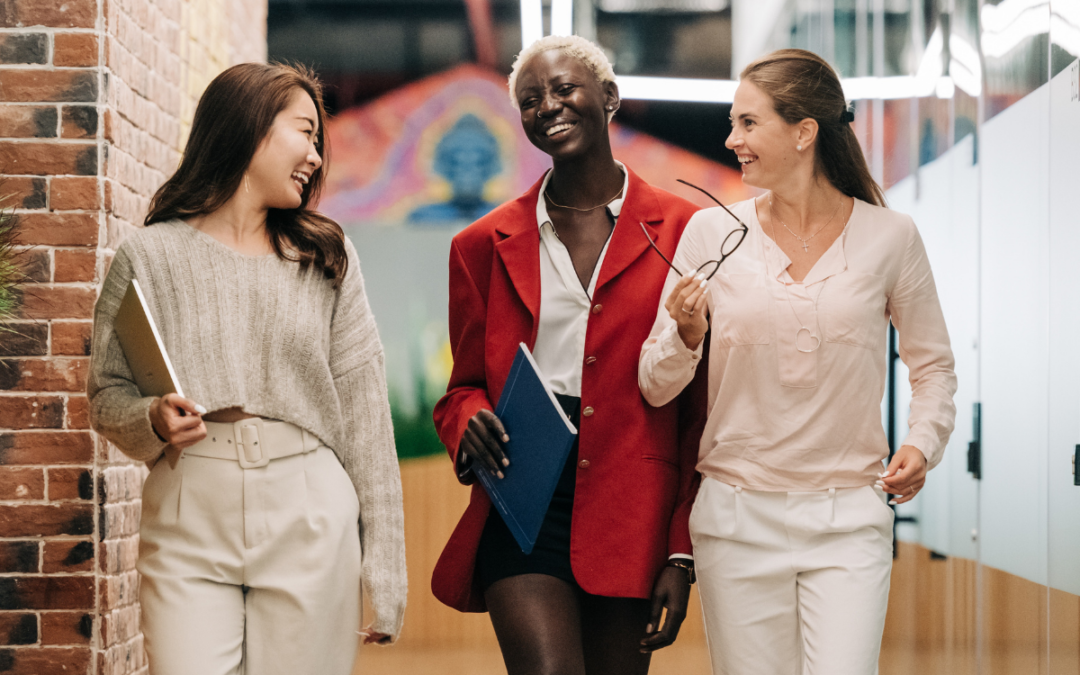 three women chatting and walking in an office