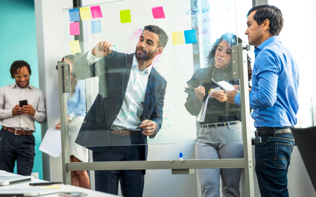 leaders standing in front of a drawing board, discussing topics